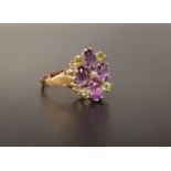 UNUSUAL 'SUFFRAGETTE' RING the oval cut amethysts and round cut peridots around a central seed pearl