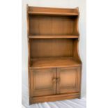 ERCOL ELM WATERFALL BOOKCASE with three shelves, shaped sides and a pair of panelled cupboard doors,