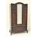 MAHOGANY WARDROBE with a shaped central door with a bevelled mirror flanked by carved floral