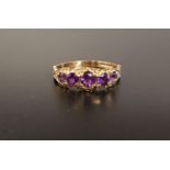 GRADUATED AMETHYST FIVE STONE RING the round cut amethysts in decorative moulded setting, on nine