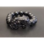 ONYX BEAD BRACELET comprising of thirteen circular beads and one carved dog of foe