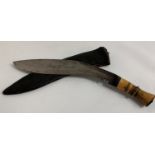 KUKRI KNIFE with a shaped blade and bone handle, contained in a leather sheath, 28.5cm long blade
