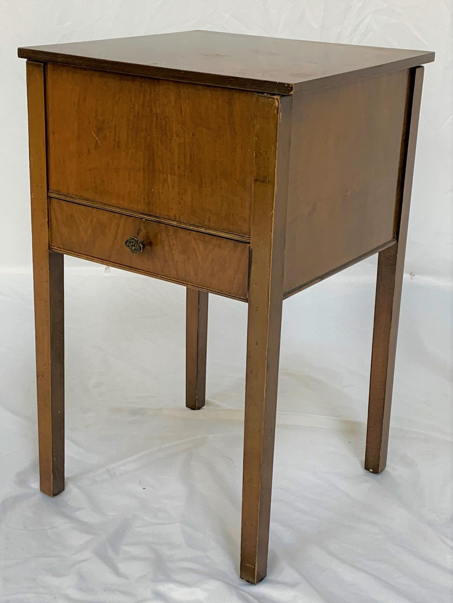 MAHOGANY SEWING TABLE with a square lift up lid revealing a pink satin lined interior, standing on