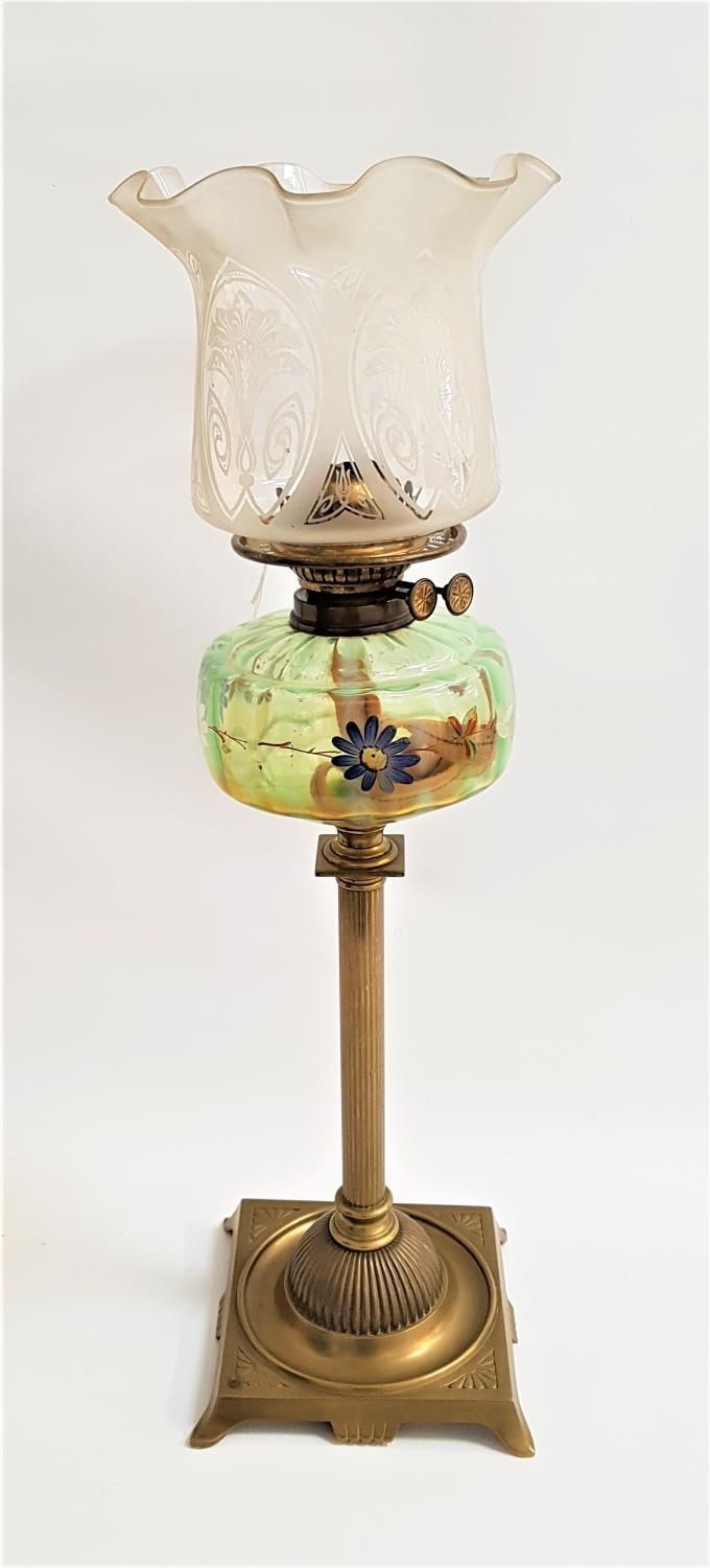 EDWARDIAN OIL LAMP with a brass square base and turned column, the reservoir painted with flowers,