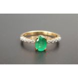 EMERALD AND DIAMOND RING the oval cut Brazilian emerald weighing 0.625cts flanked by diamond set