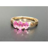 PINK TOPAZ AND DIAMOND RING the three graduated oval cut topaz gemstones flanked by two small