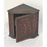 CARVED PINE SMALL CORNER CUPBOARD with a carved door and angled side panels, the interior with a