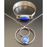 BLUE CABOCHON STONE SET PENDANT in unmarked silver and on silver chain; together with a similar