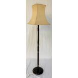 STAINED OAK STANDARD LAMP raised on a circular base with a turned column, with a shaped shade, 153cm