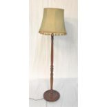 LIGHT OAK STANDARD LAMP raised on a circular base with a turned column and shaped shade, 141cm