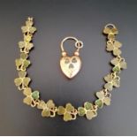 NINE CARAT GOLD HEART SHAPED PENDANT of padlock style and decorated with a green stone set three