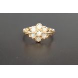OPAL CLUSTER RING the seven opal cluster flanked by decorative pierced and moulded shoulders, on
