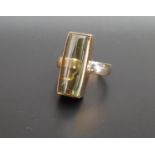 UNUSUAL GREEN TOURMALINE DRESS RING the domed rectangular gemstone approximately 2cm long, in nine