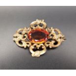 VICTORIAN CAIRNGORM SET BROOCH the pierced scroll decorated unmarked gold brooch with central oval