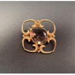 SMOKY QUARTZ SET NINE CARAT GOLD BROOCH the central oval cut quartz in quatrefoil setting, 2.7cm