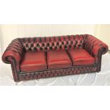 CHESTERFIELD THREE SEAT SOFA in red leather with a button back and scroll arms, with decorative stud