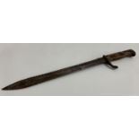 WWI GERMAN SAW BACK BAYONET with a 36cm long blade, backward quillion and two piece wooden grip