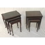 NEST OF MAHOGANY TABLES with inset glass tops and canted corners, standing on cabriole supports,