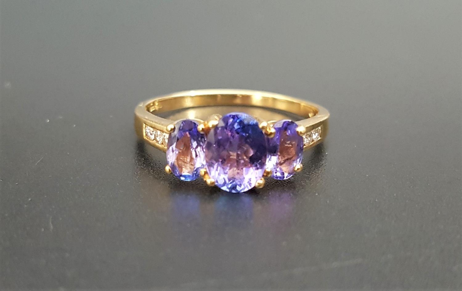 GRADUATED TANZANITE AND DIAMOND RING the central tanzanite approximately 1ct with a further