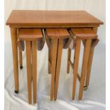 TEAK OCCASIONAL TABLE with an oblong top standing on turned supports with castors, 62cm wide, with