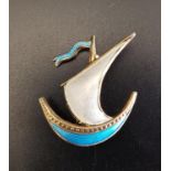 ENAMEL DECORATED SILVER BROOCH in the form of a sailing boat, decorated with blue and white