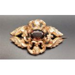 VICTORIAN QUARTZ SET BROOCH the pierced scroll decorated unmarked gold brooch with central oval