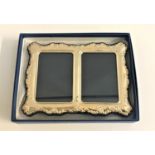 SILVER DOUBLE PHOTOGRAPH FRAME with embossed floral decoration to the shaped edges, on easel