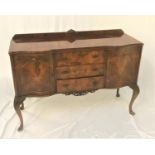 FIGURED WALNUT SERPENTINE SIDEBOARD with a shaped raised back above three central drawers flanked by