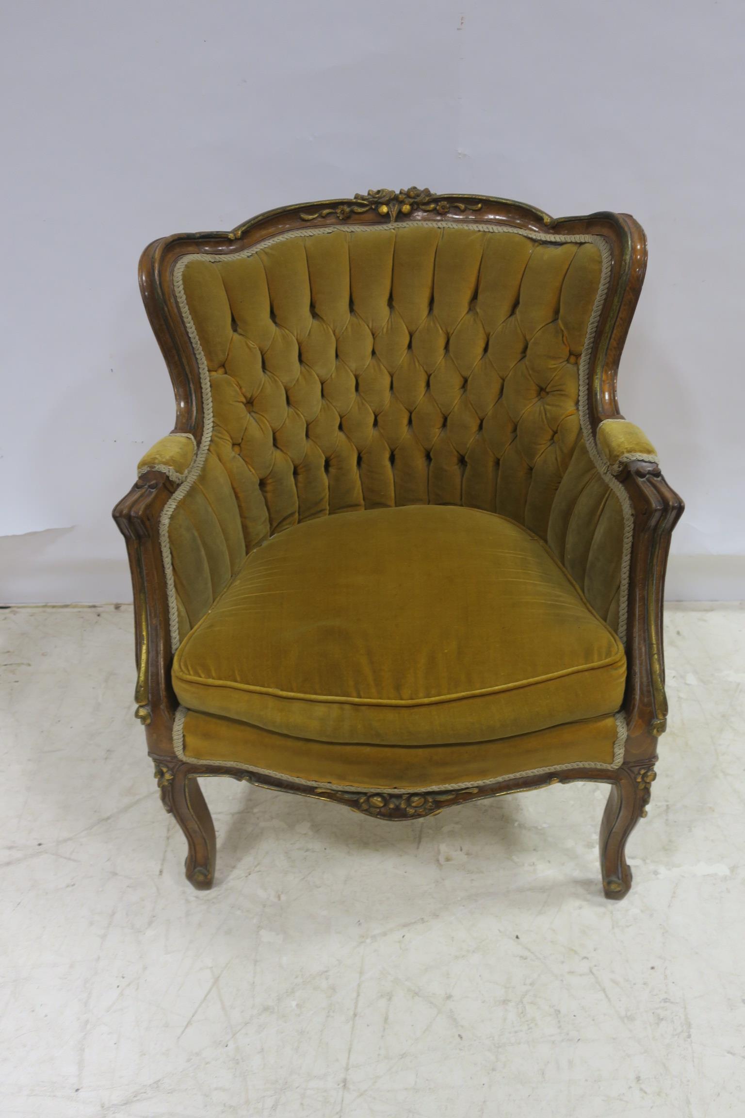 A CONTINENTAL STAINED WOOD AND PARCEL GILT ARMCHAIR the shaped top rail with foliate carving above