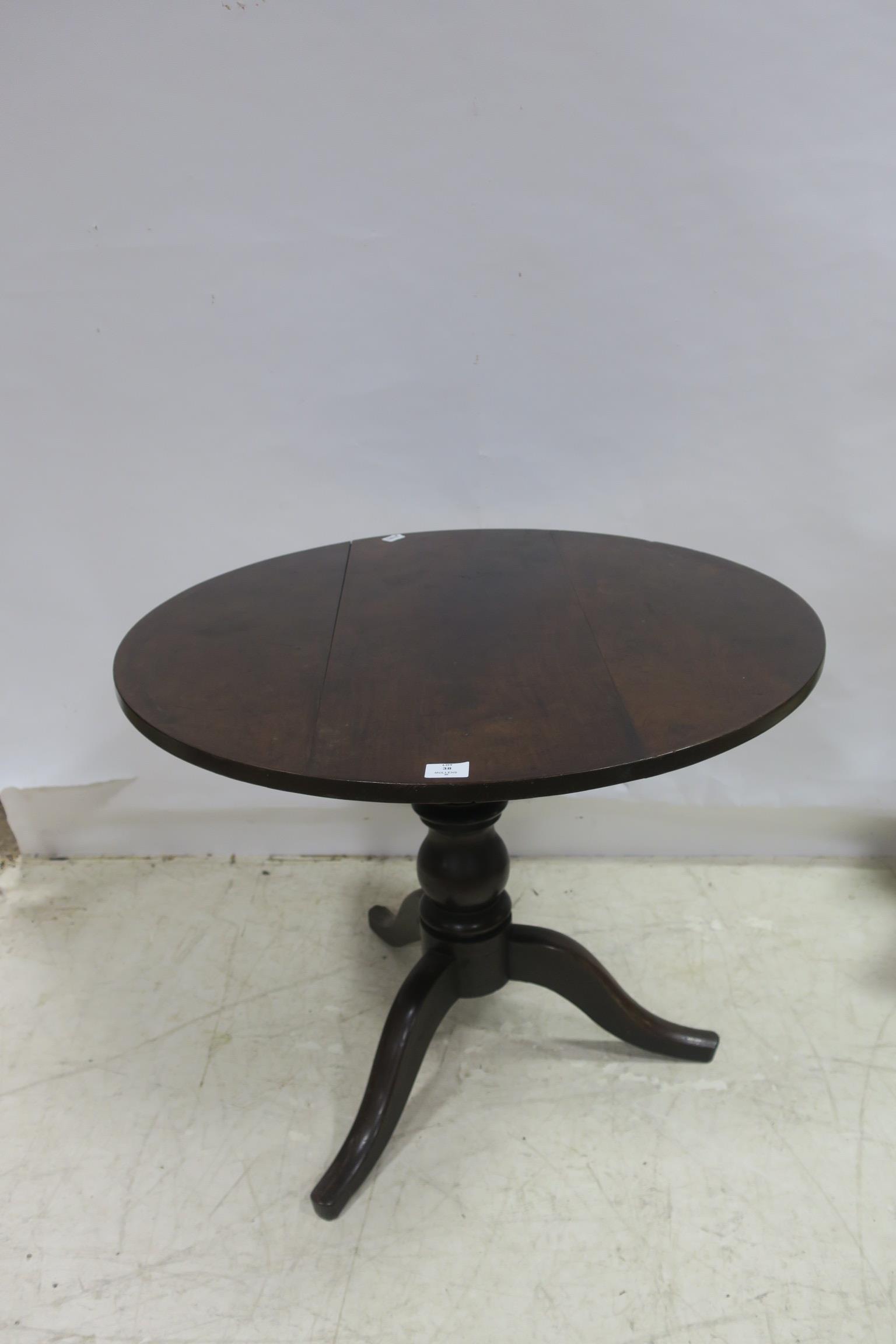 A GEORGIAN MAHOGANY TABLE the circular moulded top above a baluster column on tripod support 78cm