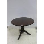 A GEORGIAN MAHOGANY TABLE the circular moulded top above a baluster column on tripod support 78cm