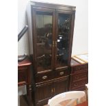 A CANADIAN STAINED WOOD AND BRASS BOUND DISPLAY CABINET of rectangular outline the shaped top above