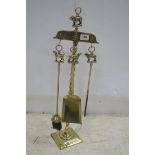 A THREE PIECE BRASS COMPANION SET with spiral twist column and figural handle raised on a square