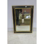 A CONTINENTAL STAINED WOOD AND PARCEL GILT MIRROR the rectangular bevelled plate within a moulded