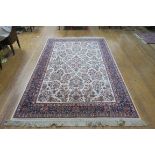 A WOOL RUG the beige and indigo ground with central floral panel within a conforming border 260cm x