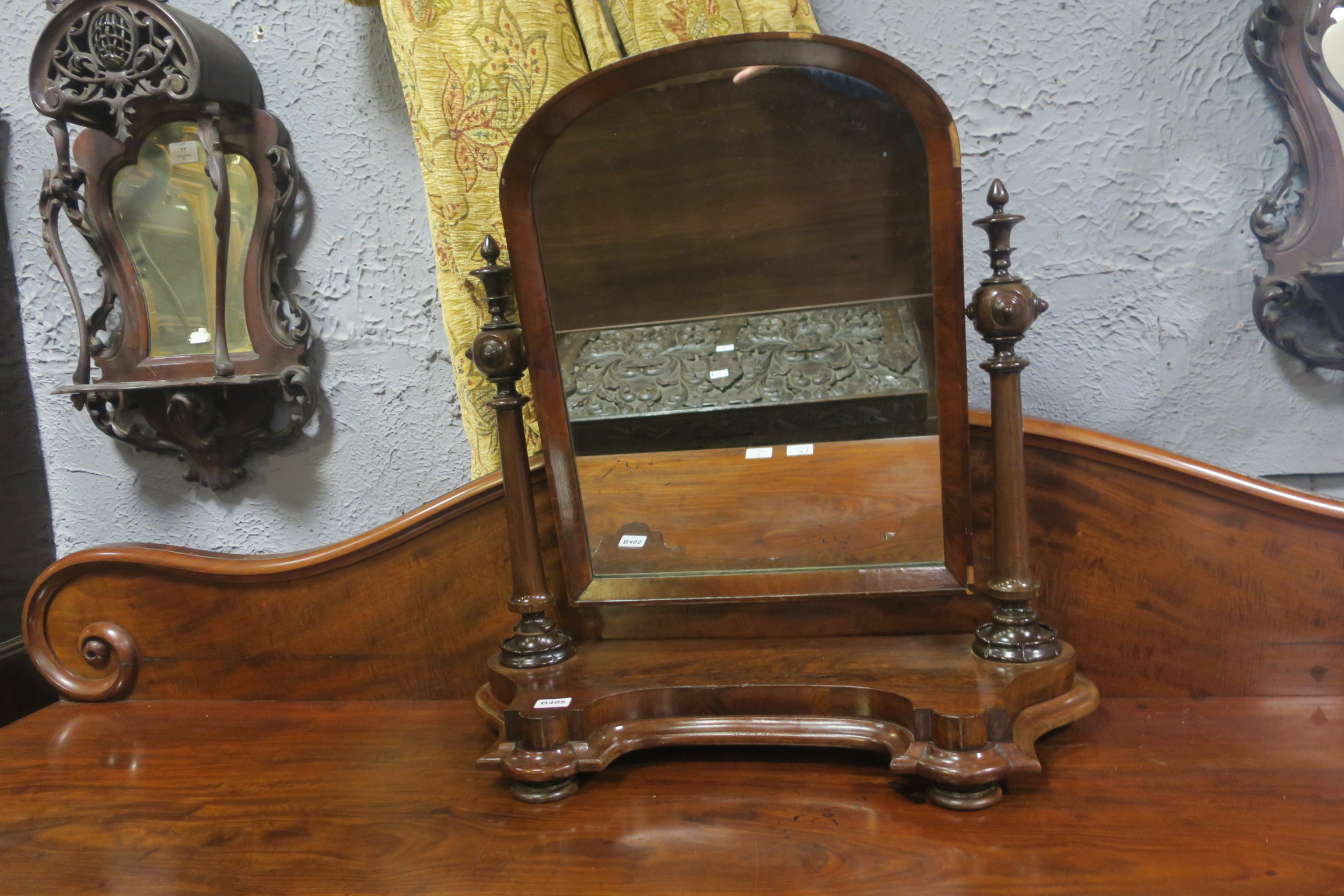 A 19TH CENTURY MAHOGANY CRUTCH FRAME MIRROR with rectangular arched plate raised on ring turn