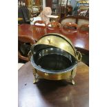 A BRASS FOOD WARMER of dome form with hinged lid and carry handles raised on splayed legs 44cm (h)