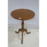 A MAHOGANY WINE TABLE the circular dish top above a baluster column on tripod support 62cm (h) x