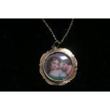 A 19TH CENTURY 18CT GOLD PENDENT with painted porcelain panel depicting two young girls on a gold