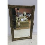 A CONTINENTAL GILT FRAMED MIRROR the rectangular plate within a moulded frame with shell and flower