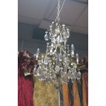 A CONTINENTAL CUT GLASS AND GILT BRASS SIX BRANCH OPEN WORK CHANDELIER hung with cut glass pendent