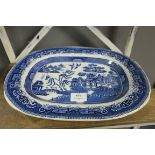 AN IRON STONE WILLOW PATTERN MEAT PLATTER of oval outline