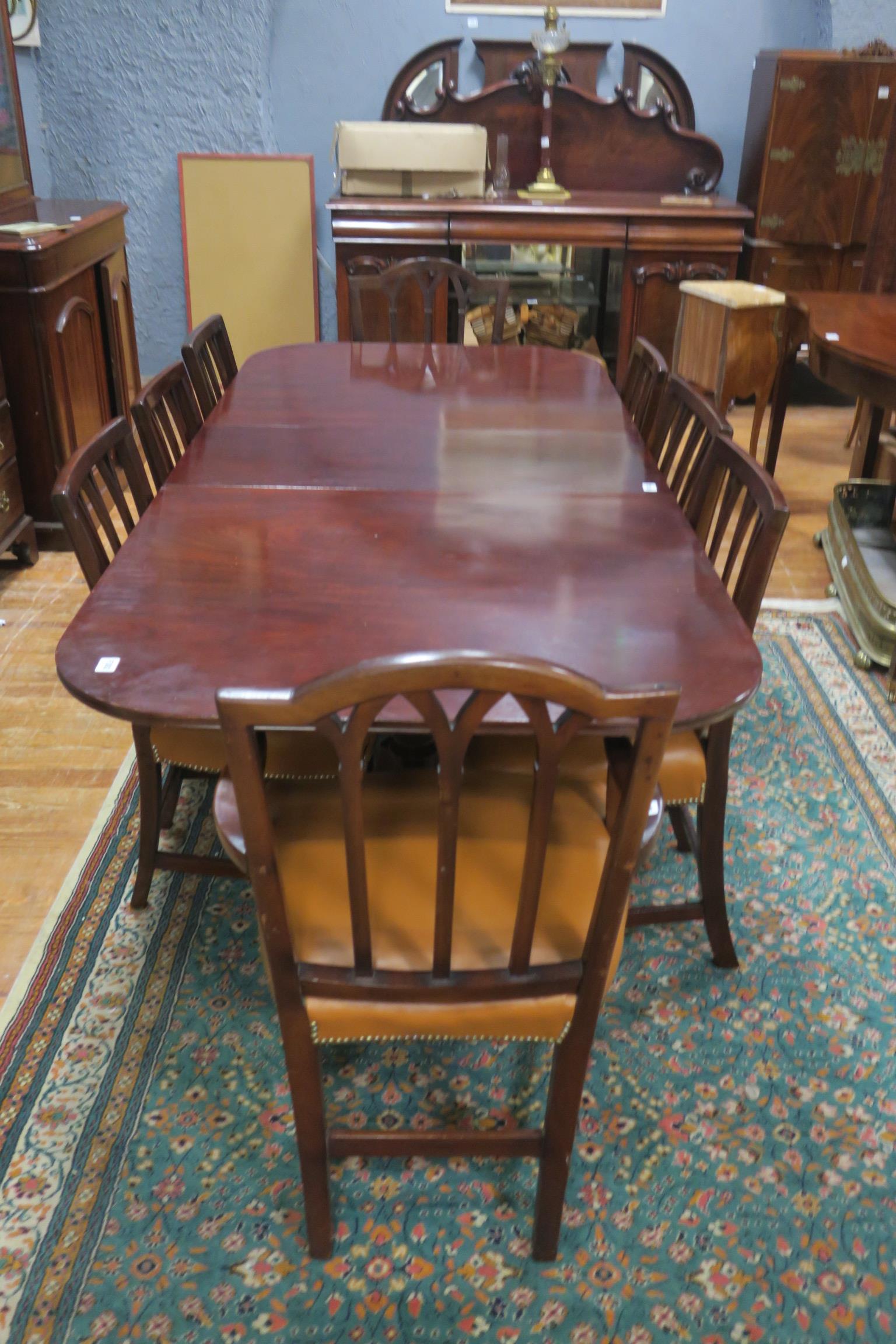 A NINE PIECE MAHOGANY DINING SUITE comprising of eight fork back dining chairs including a pair of
