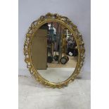 A CONTINENTAL GILTWOOD AND GESSO MIRROR the oval plate within a bead work C-scroll shell frame 83cm