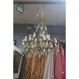 A CONTINENTAL GILT METAL AND CUT GLASS EIGHTEEN BRANCH CHANDELIER IN TWO REGISTERS hung with facet