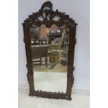 A CONTINENTAL MAHOGANY FRAMED MIRROR the rectangular plate within a flower head and foliate frame