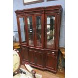 A CANADIAN STAINED WOOD CHINA DISPLAY CABINET of breakfront outline the shaped cornice above four