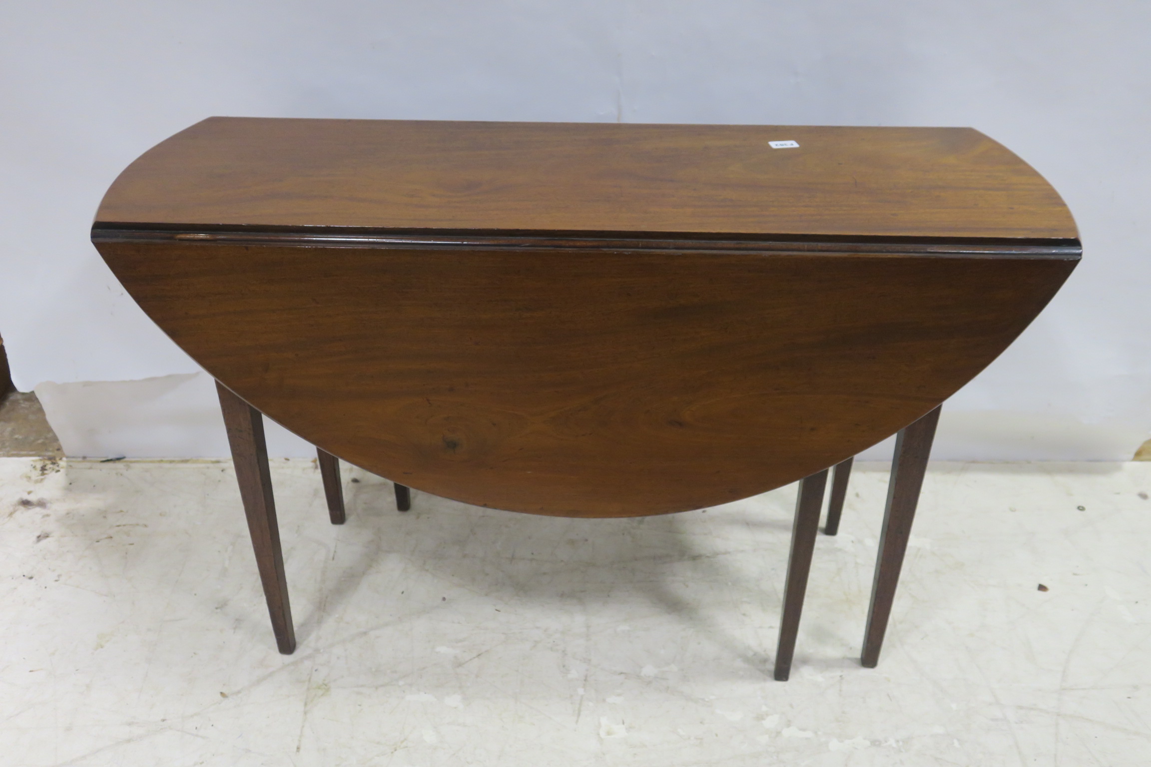 A GEORGIAN MAHOGANY DROP LEAF TABLE the oval hinged top raised on square tapering legs 74cm (h) x