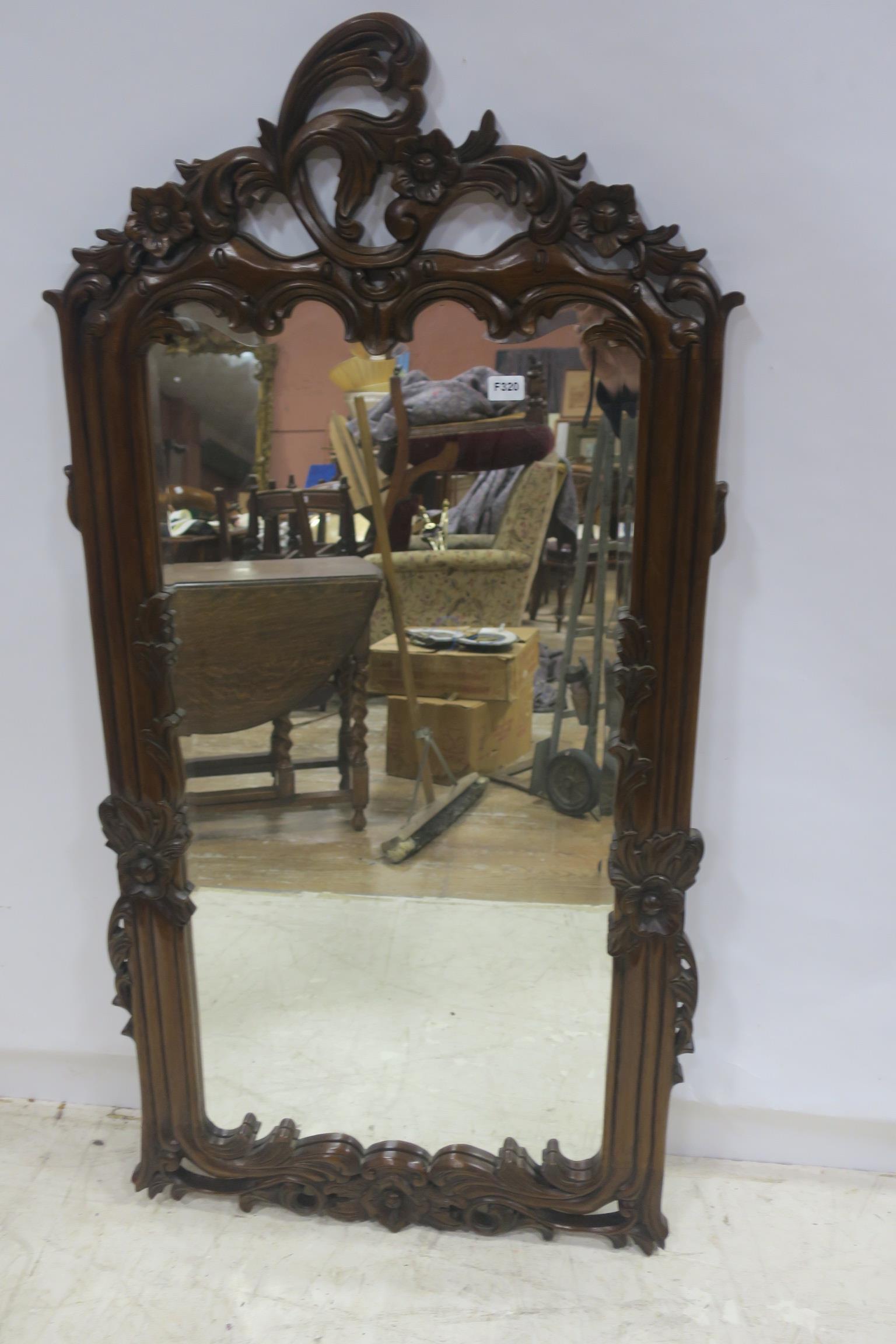 A CONTINENTAL MAHOGANY FRAMED MIRROR the rectangular plate within a flower head and foliate frame