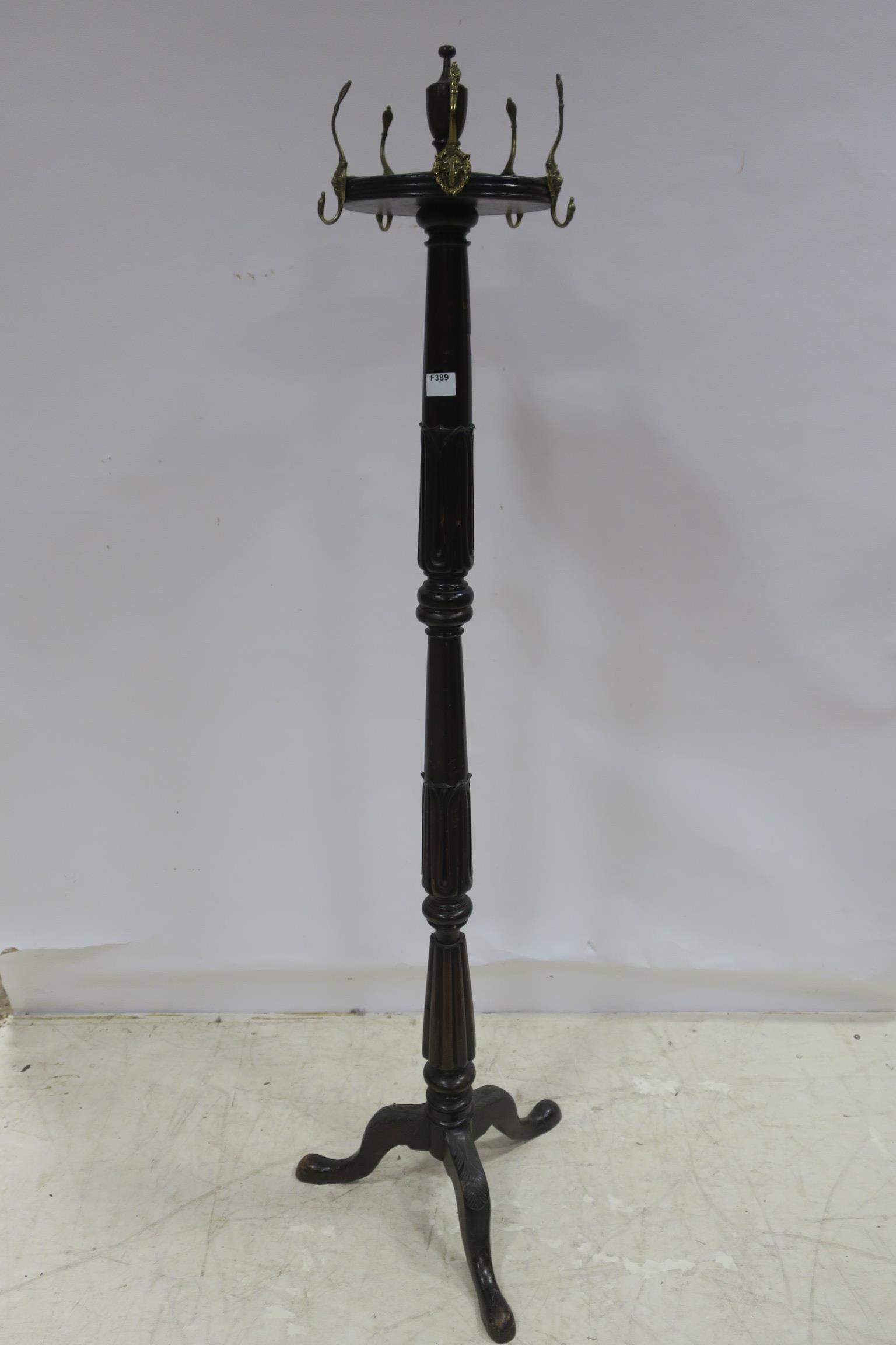 A 19TH CENTURY MAHOGANY COAT STAND the circular revolving top with brass lion mask hooks above a